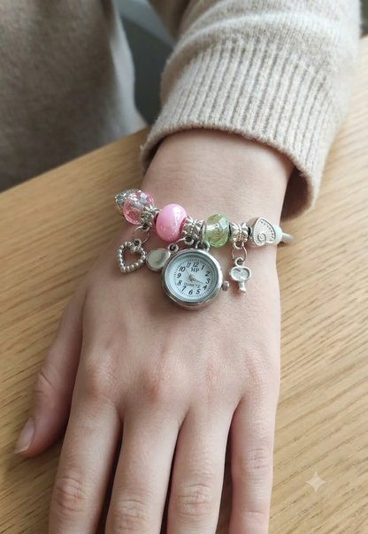 Women's bracelet watch with multicolor beads and decorative charms around the strap, featuring a round analog dial